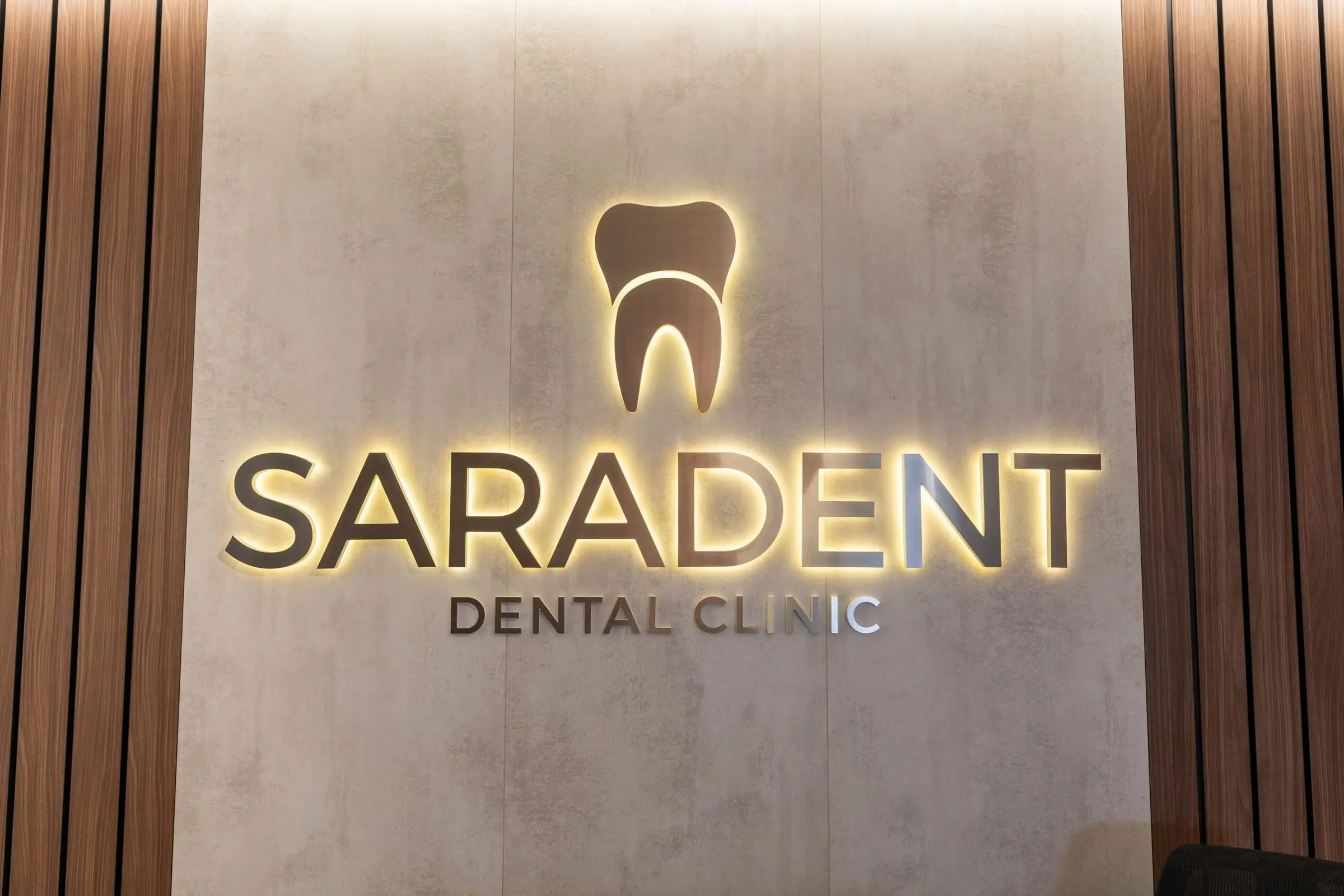Illuminated gold Saradent Dental Clinic sign on the reception wall