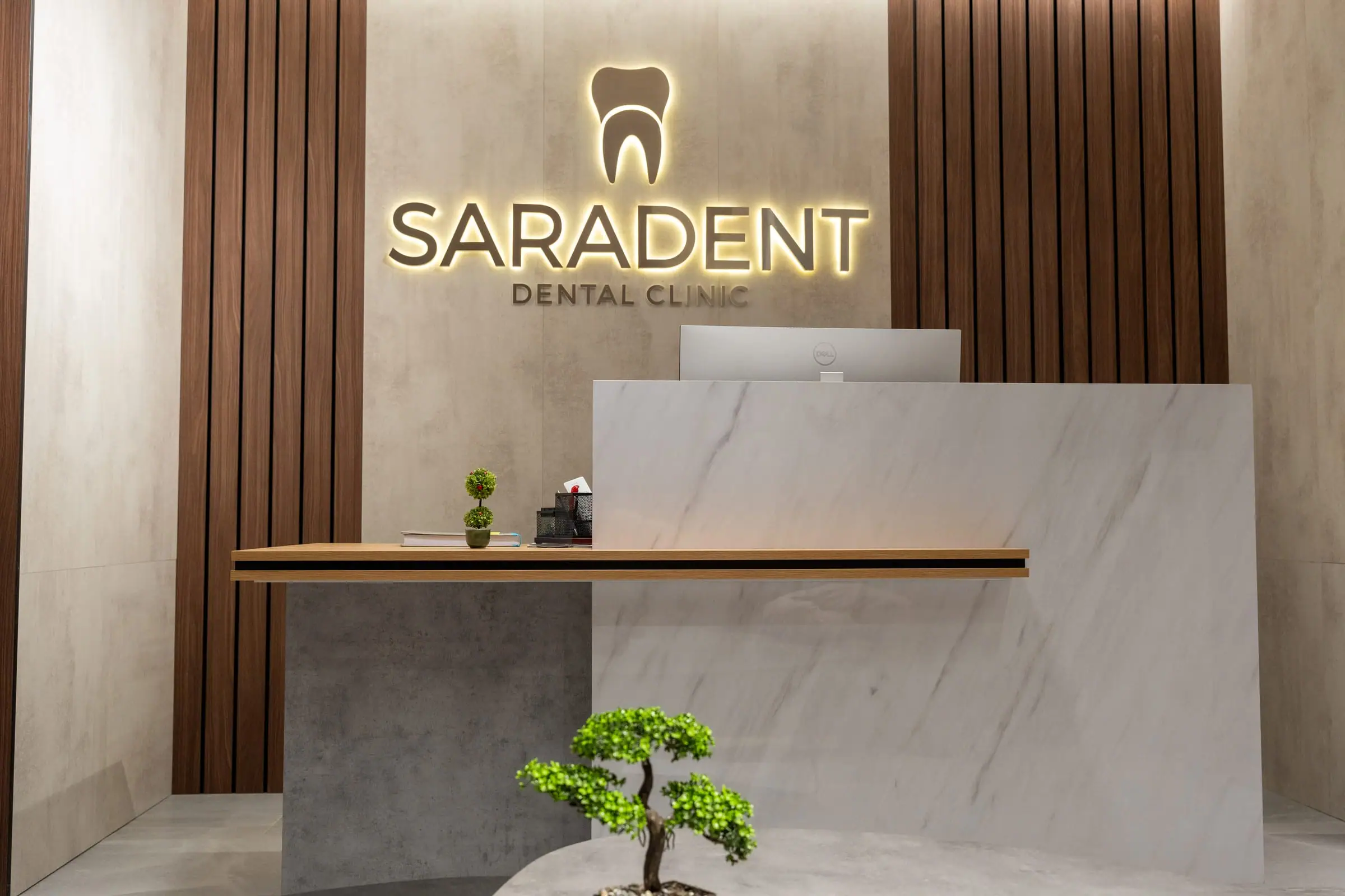 Recepcija sa logotipom Saradent i bonsai drvcem u prvom planu