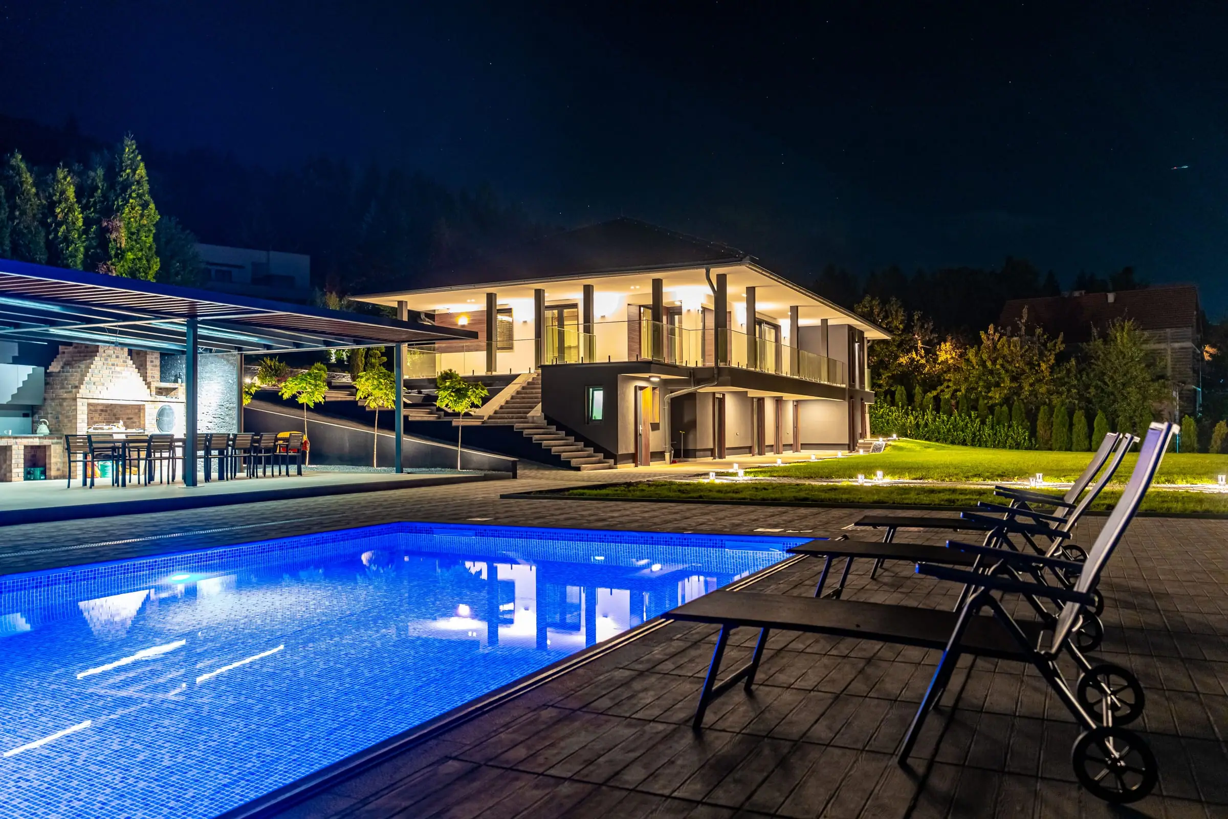 Die Hillmax Residence bei Nacht, mit beleuchtetem Pool