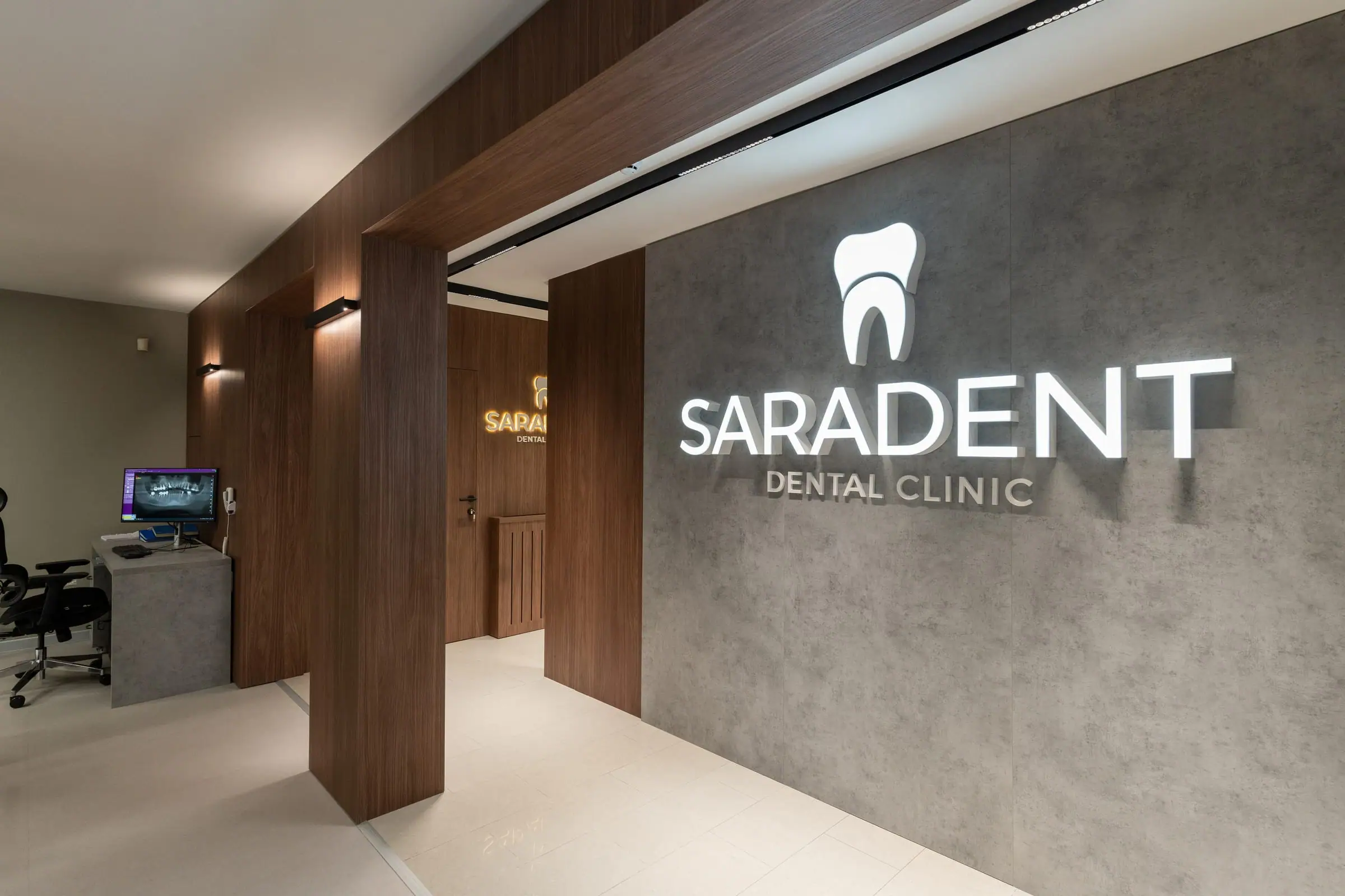 Saradent Dental Clinic sign on a concrete wall in the corridor